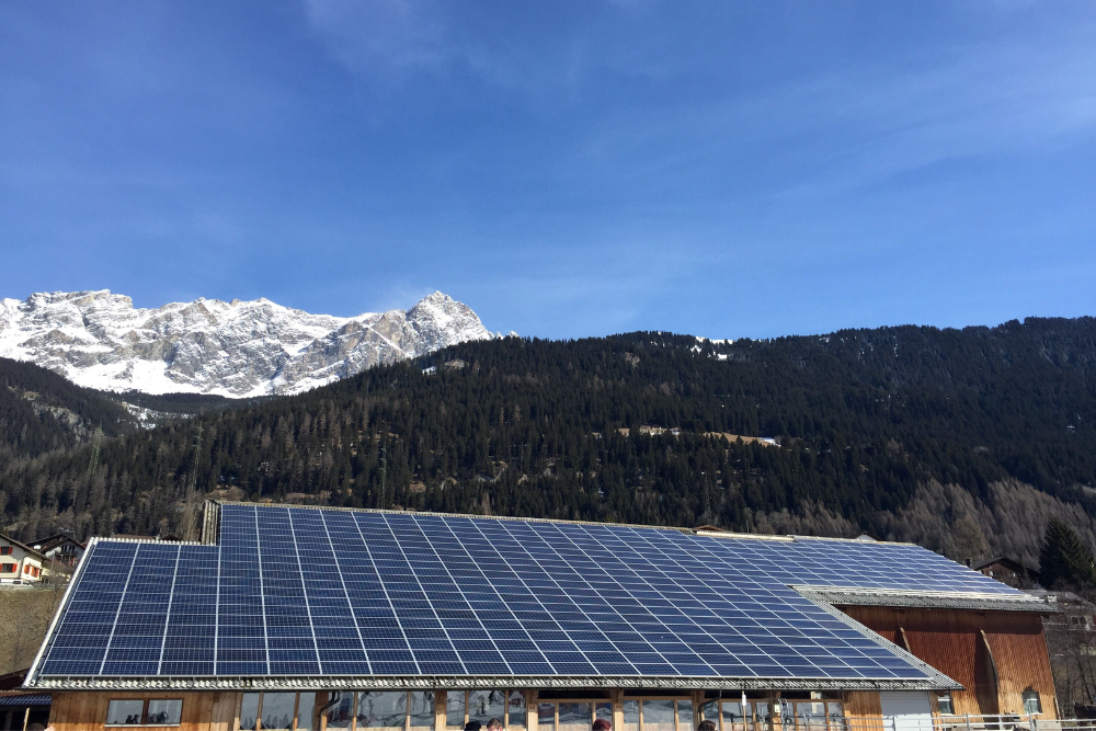 une vue de panneaux solaires sur un toit commercial face à la montagne