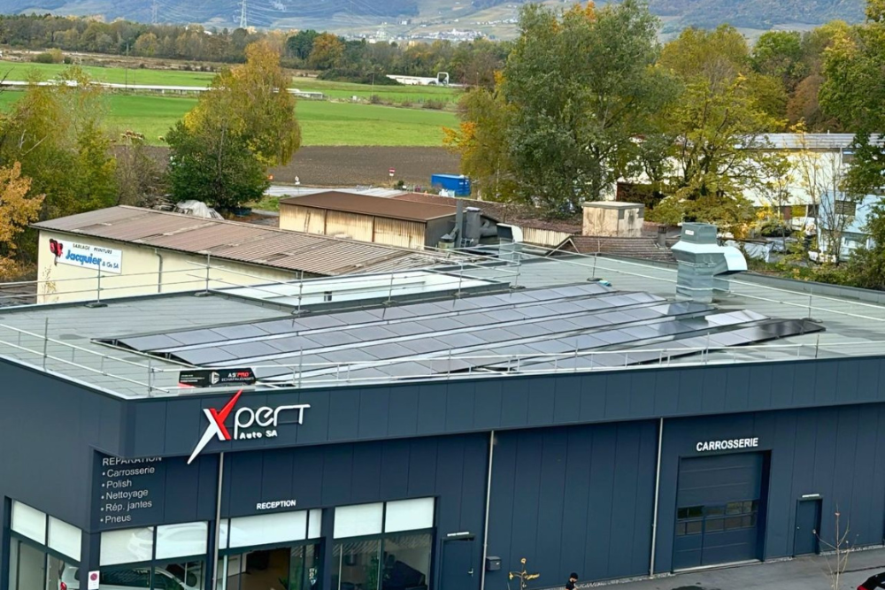 des panneaux solaires installés sur le toit d'un garage automobile dans le Valais